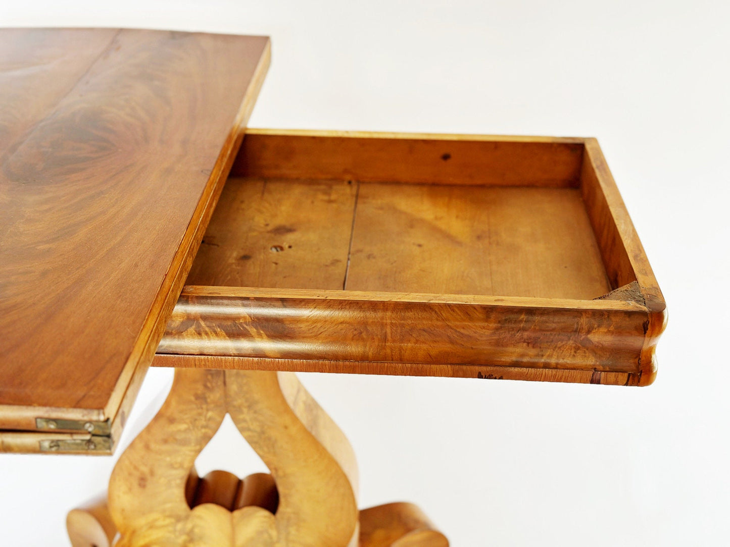 The top of the vintage antique Empire Burl wood game table twists rotates to reveal a hidden storage area for cards and games. The top has 2 pieces, one of which will fold over to extend the size of the top.