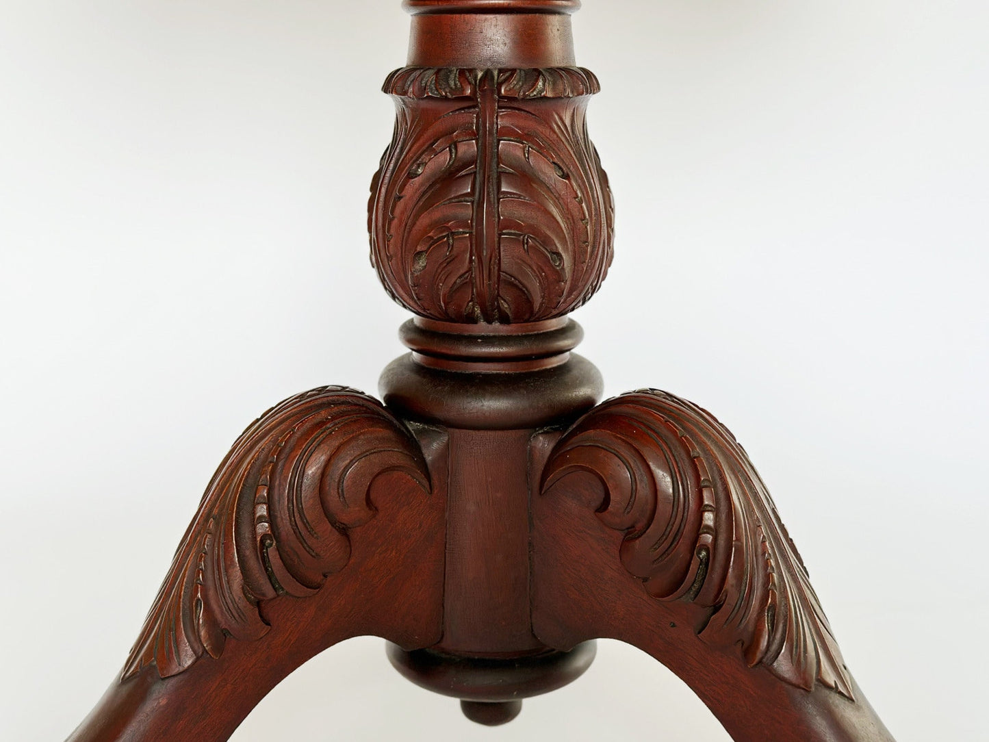 The vintage antique mahogany Empire sewing stand end table features a beautiful Acunthus urn pedestal andover the feet.