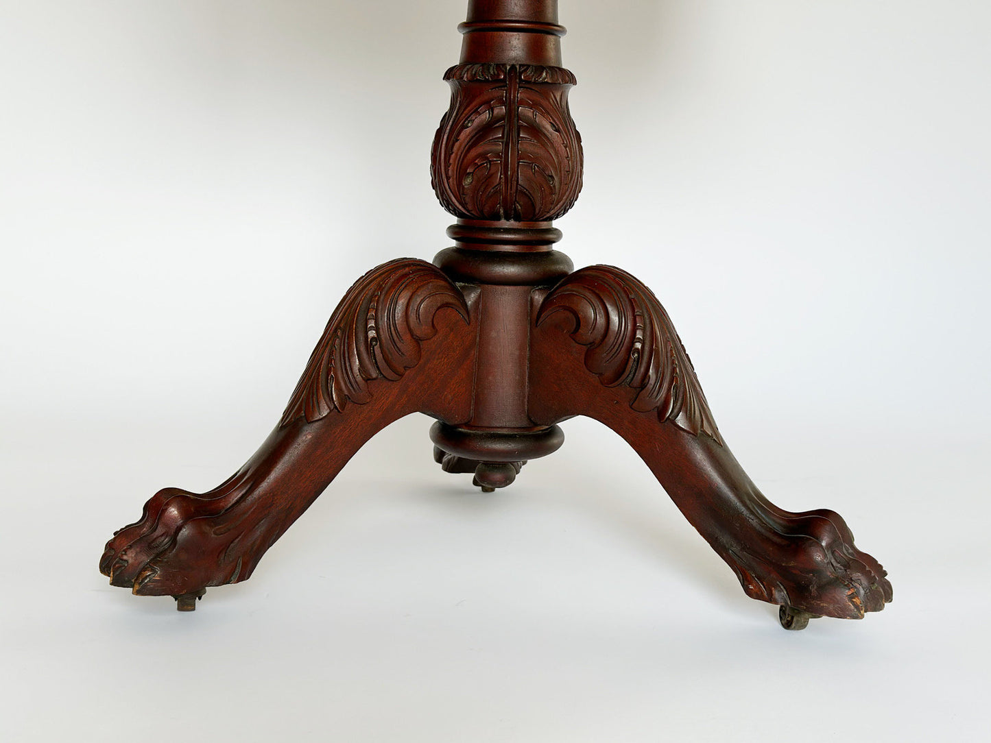 The beautifully carved mahogany claw feet on casters are stately on the antique vintage Empire sewing stand end table.