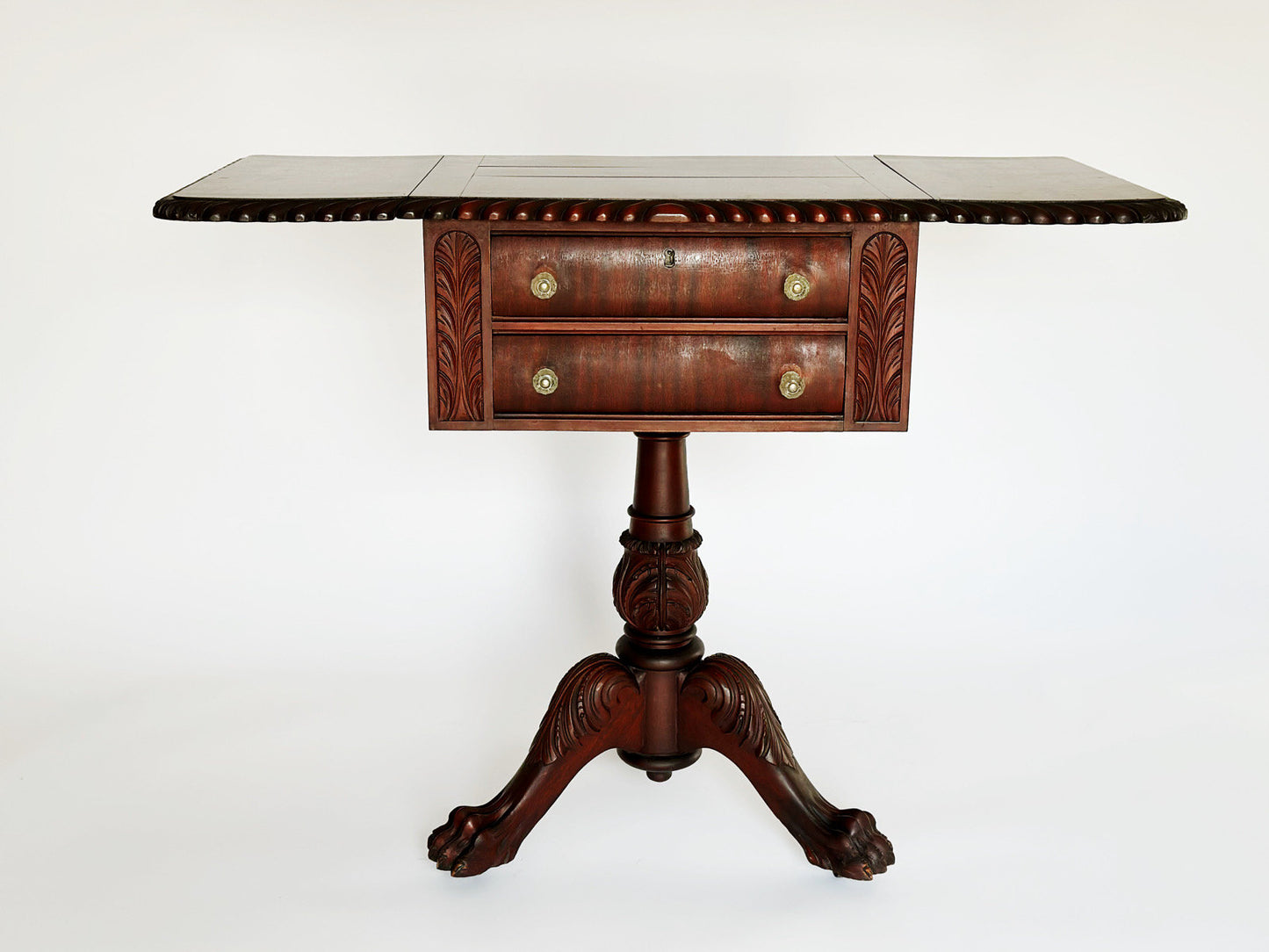 There are side arms that fold open on each side of the vintage antique Empire sewing stand to extend the size of the top of this end table.