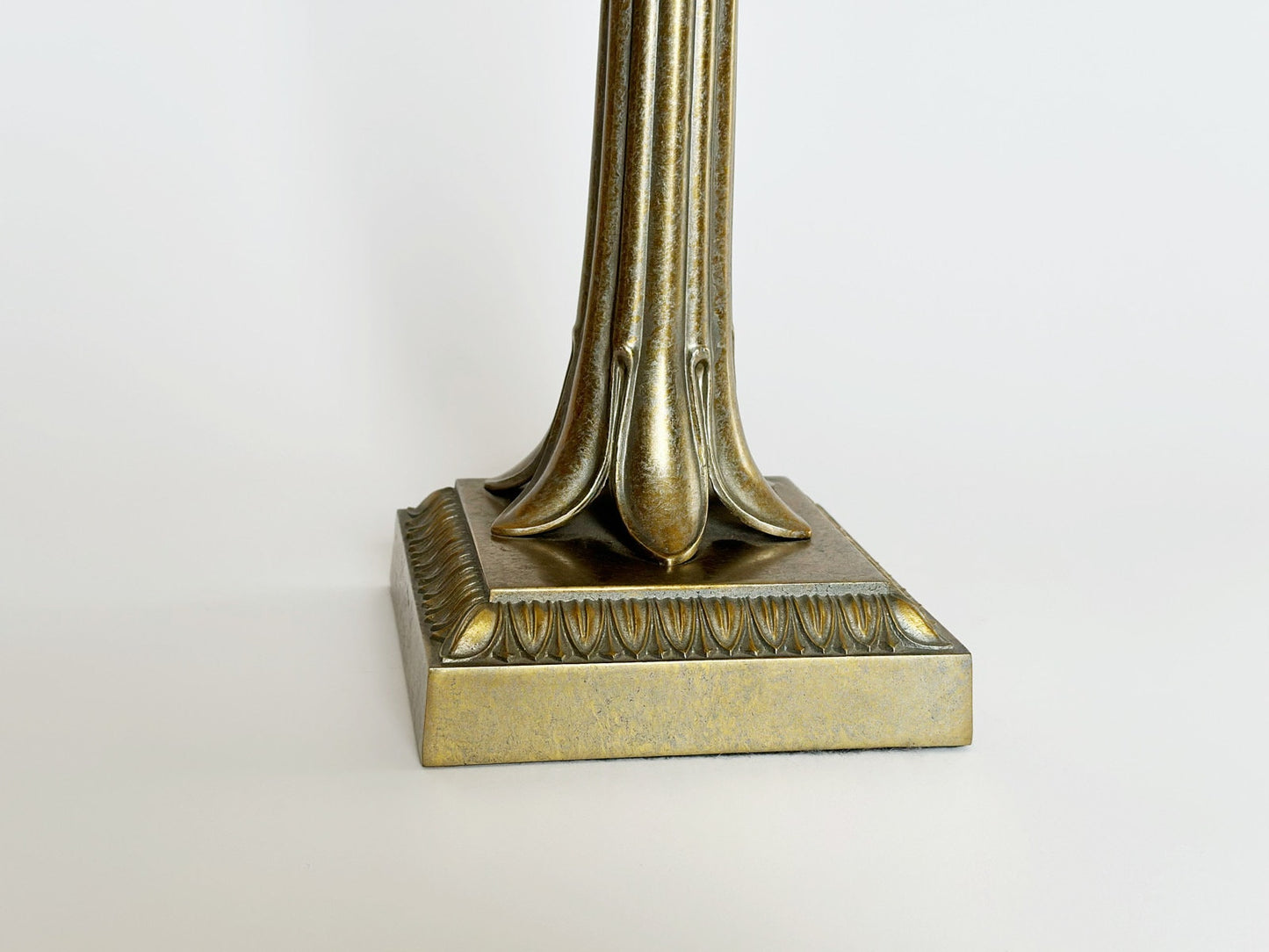 The square base of the vintage designer Frederick Cooper brass table lamp features a leaf like design.